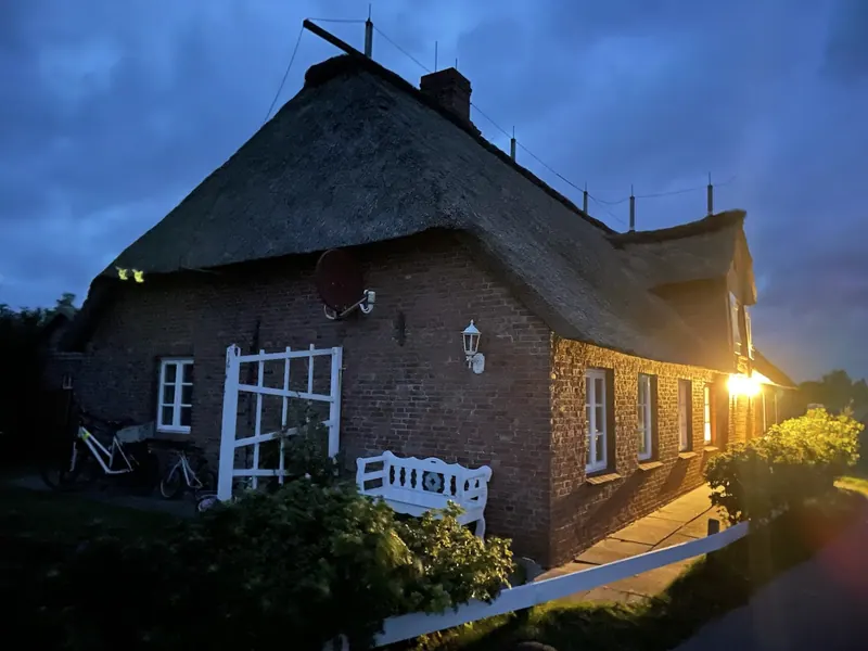Warmes Licht am Friesenhaus in der Abenddämmerung